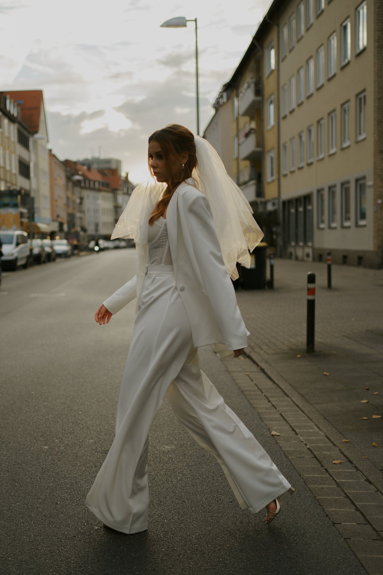 Braut in einem Hosenanzug und einem kurzen Schleier laufend über die Calenbergserstraße in Hannover 