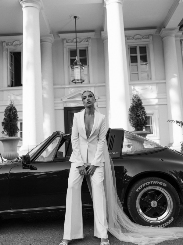 Moderner Hosenanzug für die Hochzeit mit tailliertem Blazer und weitem Bein, kombiniert mit langem Schleier - stilvolle Alternative zum klassischen Brautkleid.