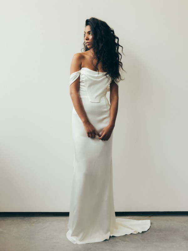 Klassisches Brautkleid aus Satin mit schulterfreiem Ausschnitt figurbetonter Silhouette und kleiner Schleppe im Studio