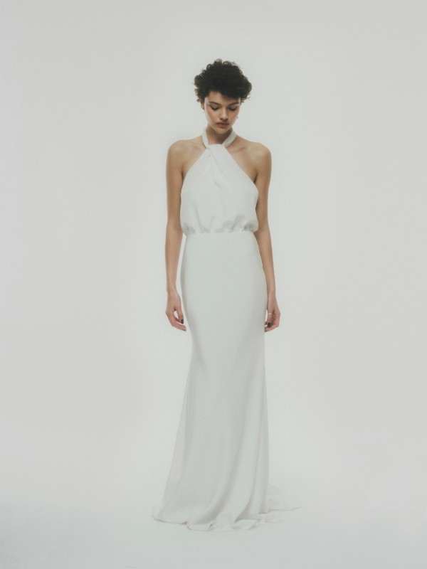 Puristisches Neckholder Brautkleid mit locker fallendem Oberteil und schmalem bodenlangen Rock im Studio