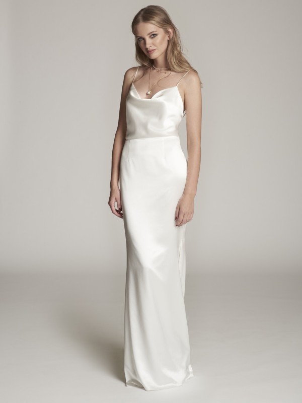 Clean-Brautkleid mit schmalen Spaghettiträgern aus Satin, minimalistische elegante Silhouette, Braut mit offenem blondem Haar vor hellem Hintergrund