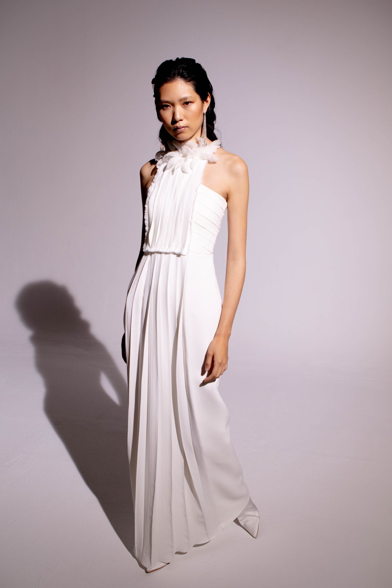 Model in einem langen Neckholder-Brautkleid aus leichtem Stoff