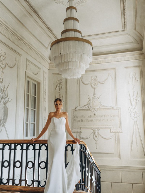 Klassisches trägerloses Brautkleid in Fit and Flare Silhouette mit Schleppe in einem historischen Saal