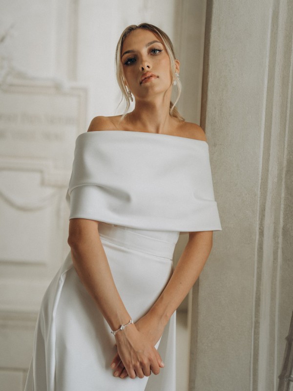 Detailansicht eines klassischen Brautkleids mit schulterfreiem drapiertem Ausschnitt in elegantem historischen Ambiente