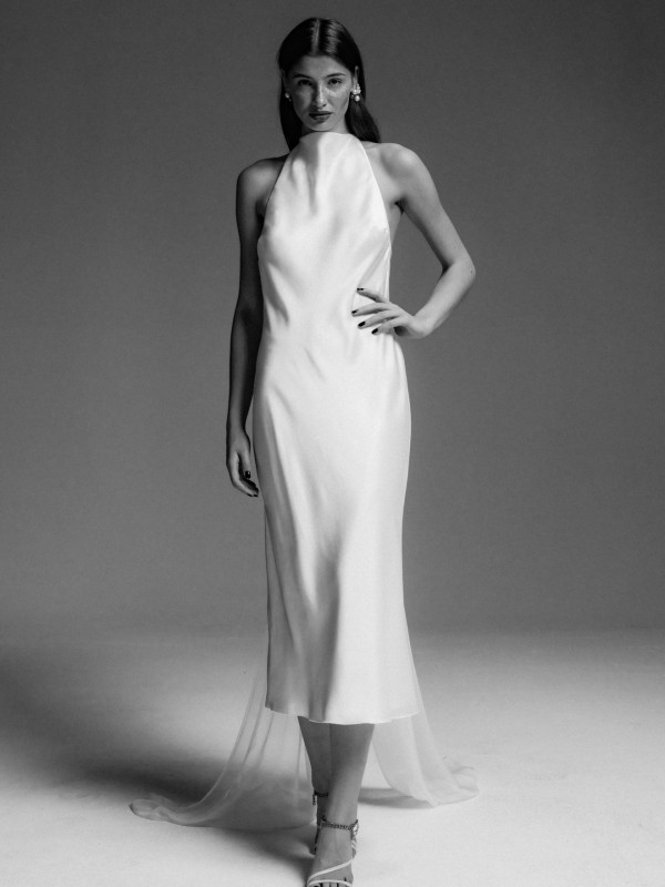 Elegantes Neckholder Brautkleid aus Satin in Midi Länge mit schmaler Silhouette und transparenter Schleppe im Studio