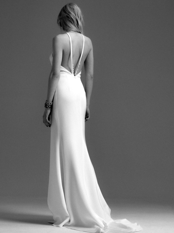 Rückenfreies Brautkleid mit doppelten Spaghettiträgern und tiefer Knopfleiste im Rückenteil sowie fließender Schleppe im Studio