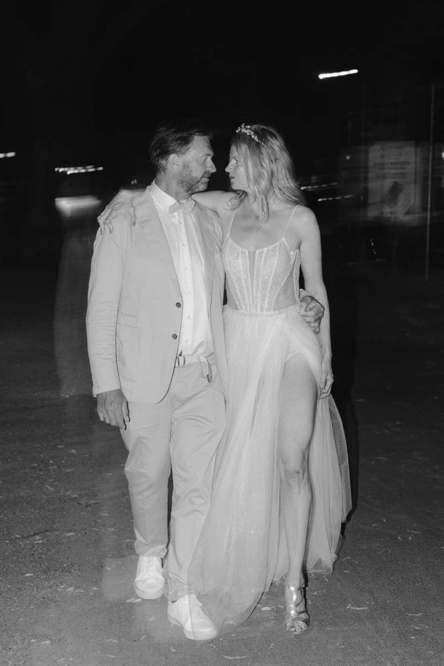 Romantische Nachtaufnahme – Real Bride Alicja in einem eleganten Tüllkleid mit Corsagen-Oberteil, Hand in Hand mit ihrem Bräutigam. Fotografiert von Filipp Romanovski.