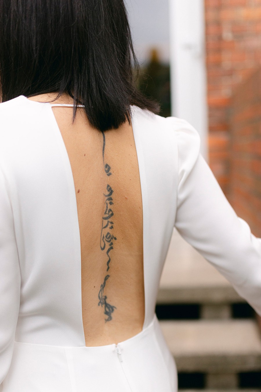 Rückenfreies Brautkleid in modernem Design – Real Bride Margitta trägt das Kleid Be Incredible mit tiefem Rückenausschnitt, fotografiert von Filipp Romanovski.