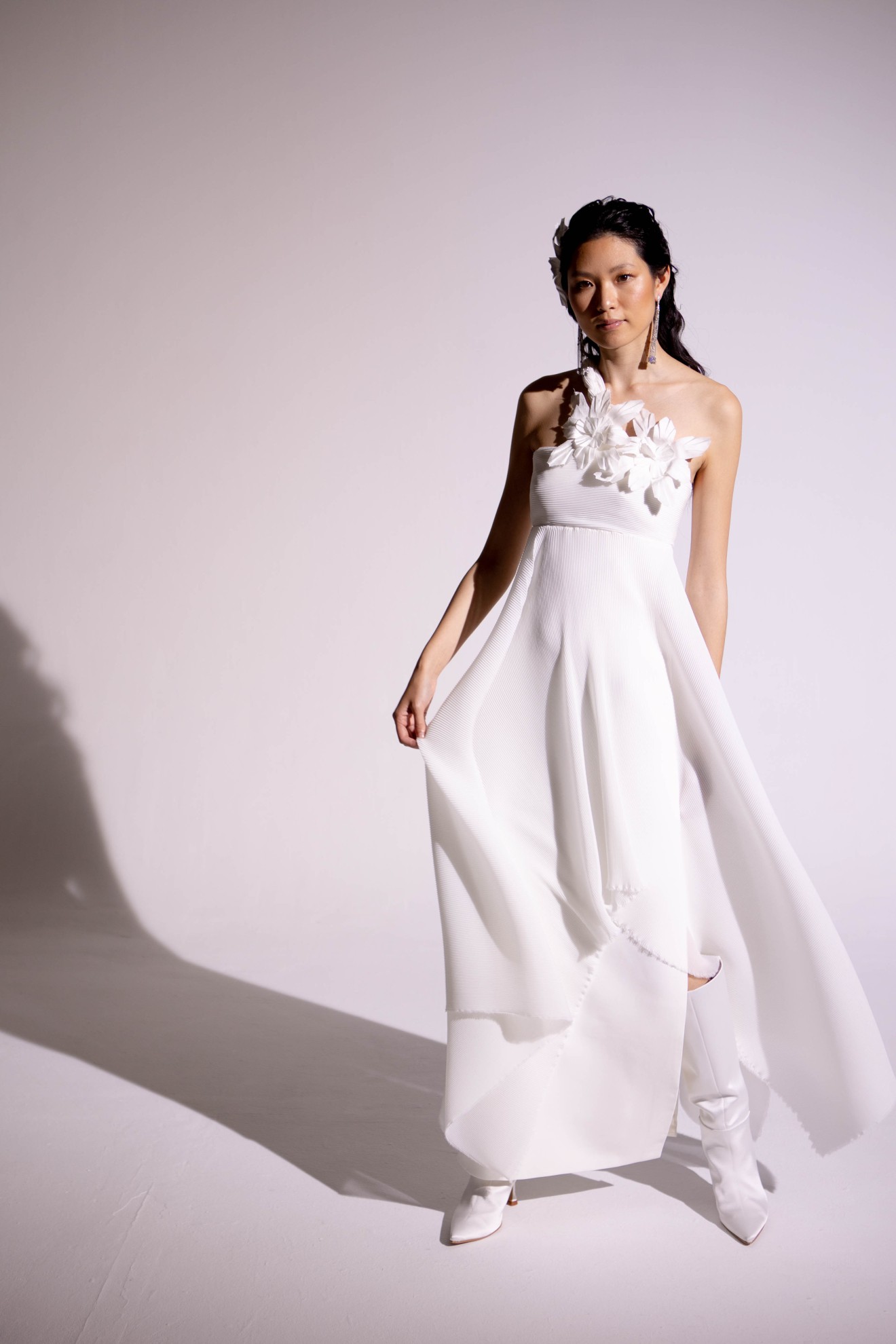 Eine Braut in einem schlichten und elegenten Brautkleid steht vor der Kamera