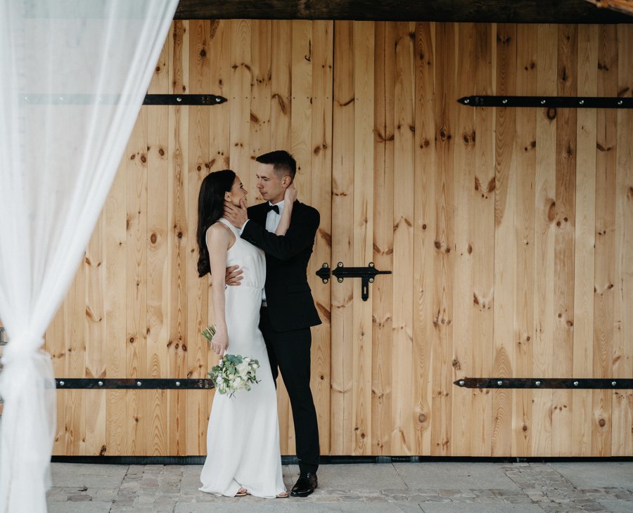 Brautpaar vor eine große Holztür mit Vorhang