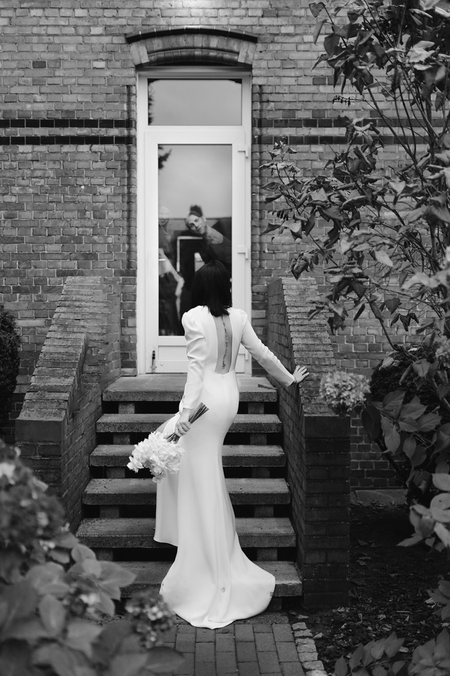 Eine Braut stehend vor einer Treppe mit dem Rücken zur Kamera