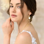 Model mit vergoldeten Ohrringen 'Regia' und Perlen, Vorderansicht, stilvoller Schmuck für Hochzeiten. thumbnail