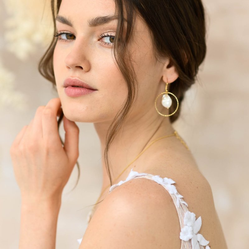 Model mit vergoldeten Ohrringen 'Regia' und Perlen, Vorderansicht, stilvoller Schmuck für Hochzeiten.