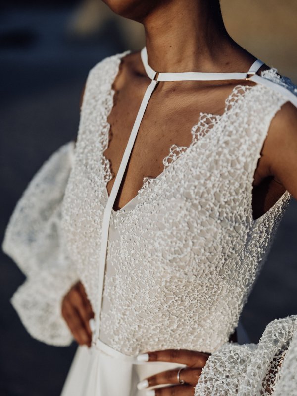 Detailaufnahme des Boho-Brautkleids von Kisui Berlin mit einem raffinierten Harness-Design am Oberteil und feiner Spitzenstruktur, die das Kleid zu einem einzigartigen Hingucker macht.