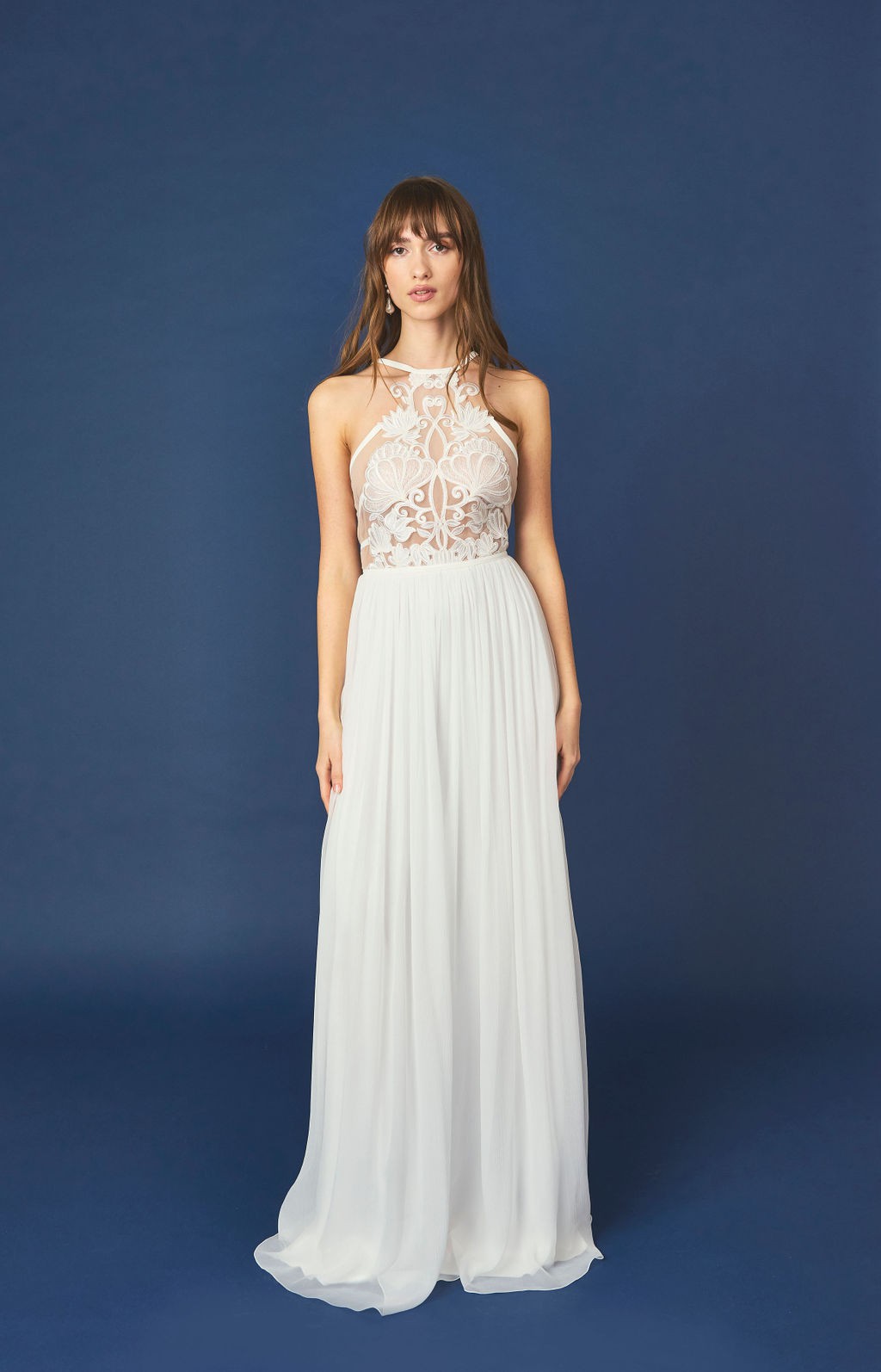 Romantisches Neckholder-Brautkleid mit aufwendigem Spitzenoberteil und fließendem Rock – perfekt für eine feminine und verträumte Hochzeit.