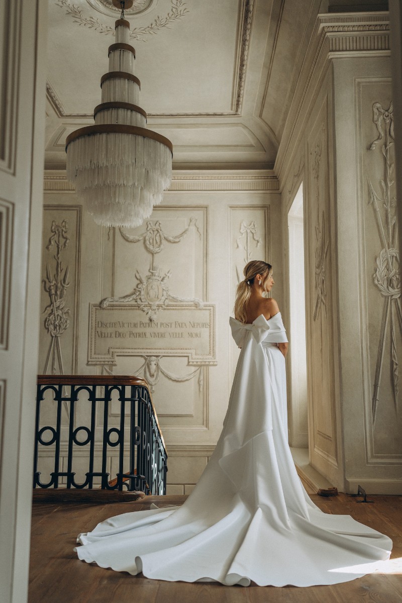 Schulterfreies Brautkleid mit voluminösem Rock und eleganter Schleppendetail – ein klassischer und majestätischer Look.