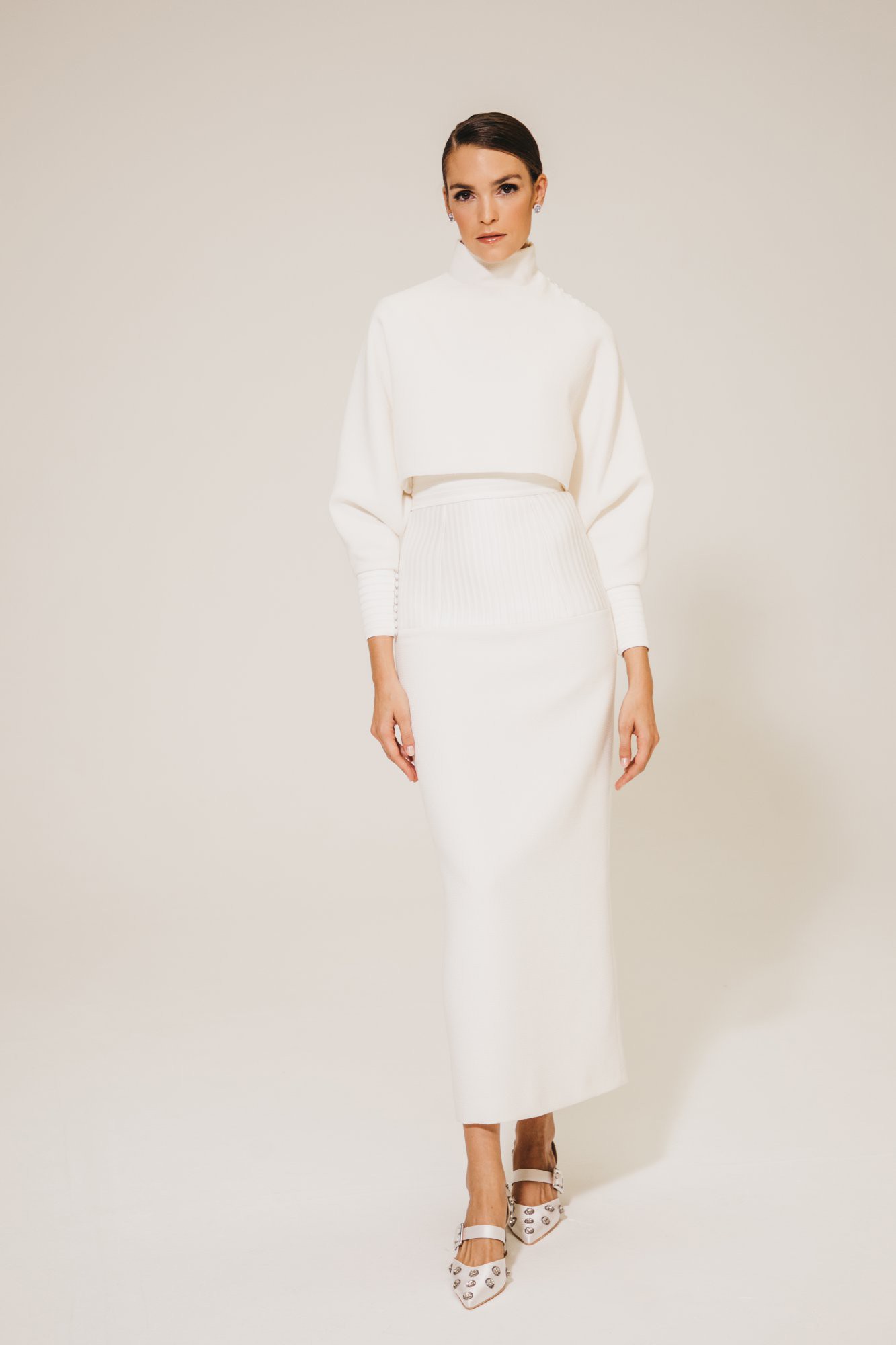 Schlichter Brautzweiteiler mit hochgeschlossenem Oberteil und eleganter, figurbetonter Rock-Silhouette – ein minimalistischer und stilvoller Look.