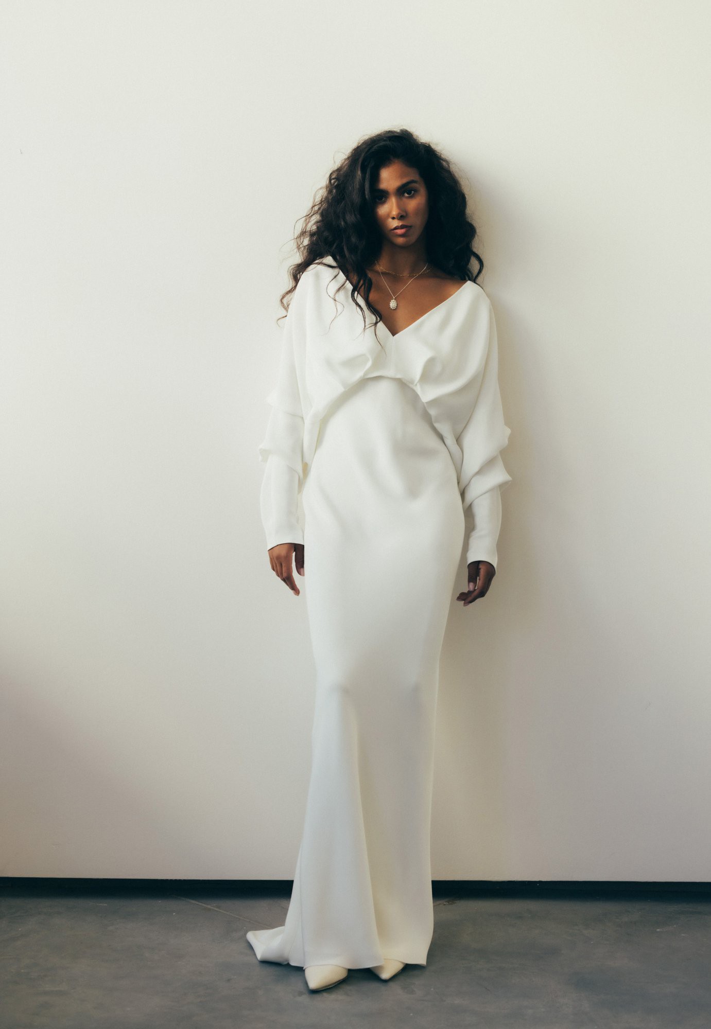 Modernes Brautkleid mit asymmetrischem Ausschnitt und fließendem Stoff – ein minimalistischer Look mit innovativen Details.