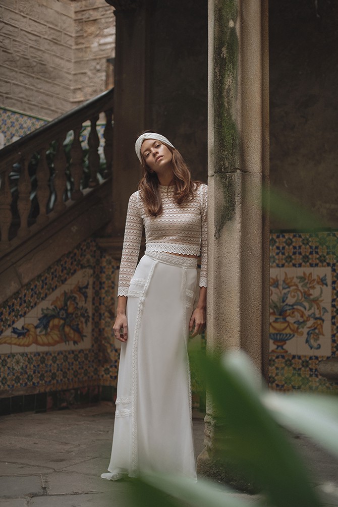 Elegantes Boho Brautkleid, Braut in weißem Spitzenoberteil und langem Rock, fotografiert vor einem historischen Gebäude.